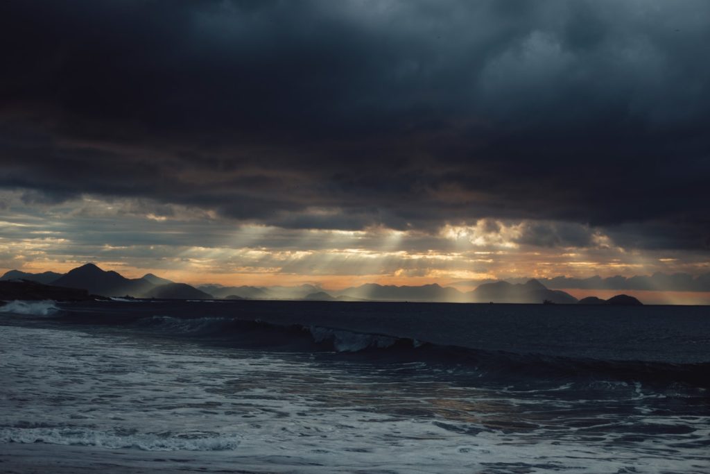sea waves crashing on shore during sunset